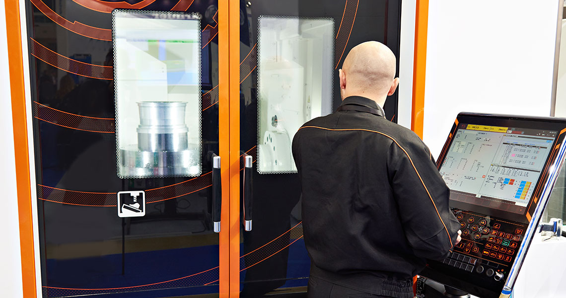 A person operating an industrial machine with a digital control panel. Text overlay: "We needed an alternative to traditional dedicated control systems—Xentara gives us a flexible, open, real-time platform for our systems and machines."